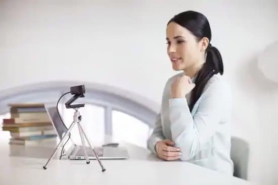 Woman using web camera with tripod