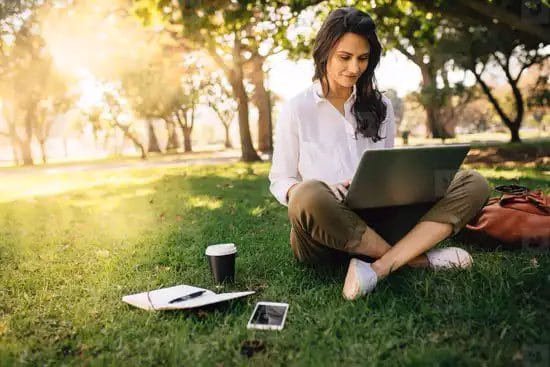 Mujer usando notebook al aire libre